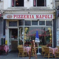 the outside of a restaurant with tables and chairs