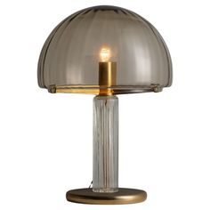 a glass table lamp with a gold base