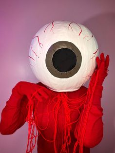 a person wearing an eyeball costume and holding up their hands in front of his face