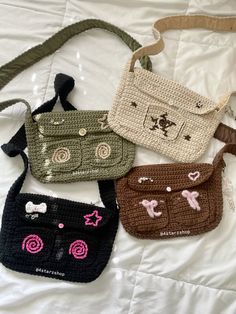 four crocheted purses sitting on top of a white bed next to each other