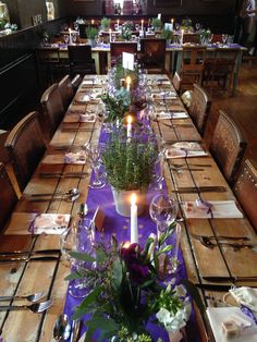 the table is set with purple linens and place settings