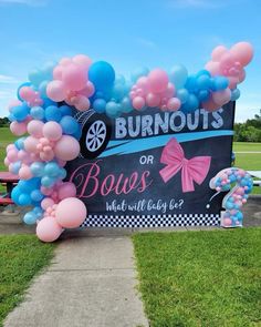 a bunch of balloons that are in the grass near a sign with words burnouts or bows on it