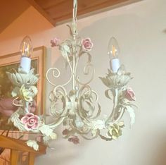 a chandelier hanging from the ceiling in a room with pink and white flowers