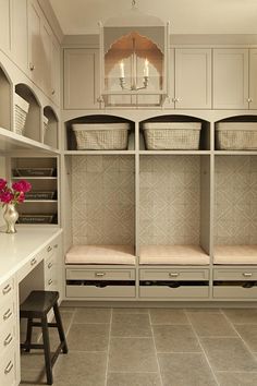 an organized walk in closet with white cabinets and drawers