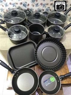 pots and pans are sitting on a table with the lids down, ready to be used