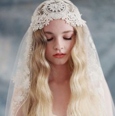 a woman with long blonde hair wearing a white veil and headpiece on her head