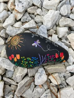 a painted rock sitting on top of some rocks