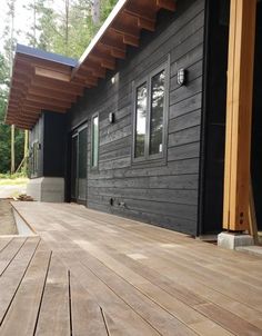 a house that is made out of wood and has black siding on the side of it