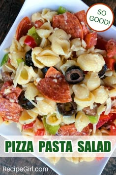 this pasta salad has pepperoni, olives, and other toppings on it