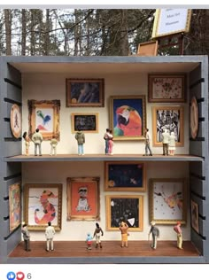 an open shelf with pictures and figurines on it in front of some trees