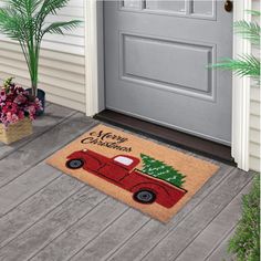 a red truck with a christmas tree on the front door mat