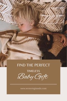 a little boy laying in bed under a blanket with a teddy bear on it and the words find the perfect timeless baby gift