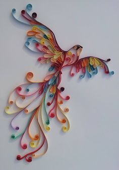 a colorful bird made out of buttons on a white surface with an intricate design in the middle