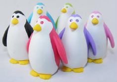 a group of plastic penguins standing next to each other on top of a white surface