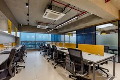 an empty office with yellow and black chairs