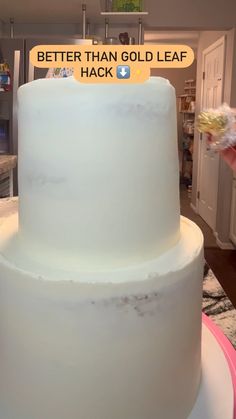 a white cake sitting on top of a counter next to a sign that says better than gold leaf hack