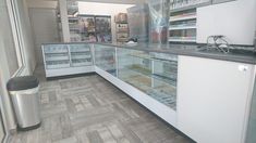 the inside of a store with many items on display in glass cases and metal trash cans