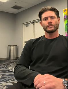 a man sitting in an office with his hands crossed