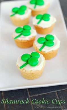 cupcakes with green frosting and shamrock decorations on a white plate, ready to be eaten