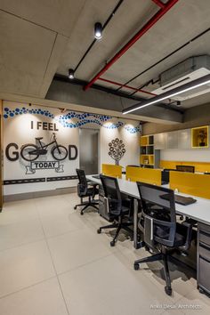 an office with yellow and black desks and chairs in front of a sign that says i feel good today