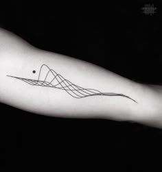 a black and white photo of a person's arm with a wave tattoo on it