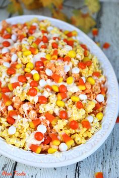 a white plate topped with popcorn and candy corn