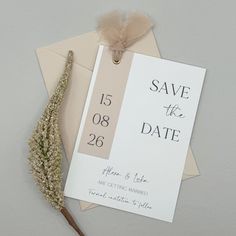 a wedding save the date card next to a dried flower on top of an envelope