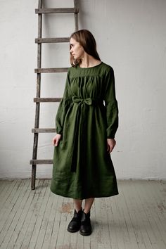 Victorian dress is made from 100% soft and washed linen. Details: - Colour: Forest green - Composition: 100% Oeko-Tex certified linen - Grey ribbon in the back - Ruffled long sleeves - Pockets - Belt included - Medium weight linen - Linen care: machine wash gentle; tumble dry low, ironing optional - The price is for one dress, other pictured items are not included Dark Green Linen Dress, Spring Olive Linen Dress, Green Linen Dress For Daywear, Green Linen Daywear Dress, Green Relaxed Fit Linen Dress, Green Linen Dress For Fall, Green Linen Dresses For Fall, Green Victorian Dress, Victorian Aprons