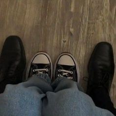 two people wearing black and white shoes standing next to each other on a wooden floor