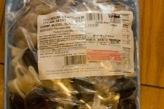 a plastic bag filled with lots of black and white items on top of a wooden table