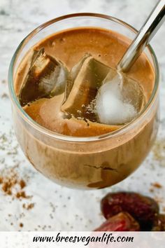 a glass filled with ice and some nuts