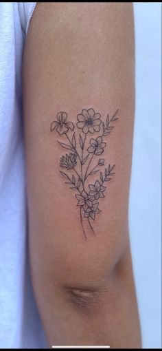 a woman's arm with flowers on it and the word love written in black ink