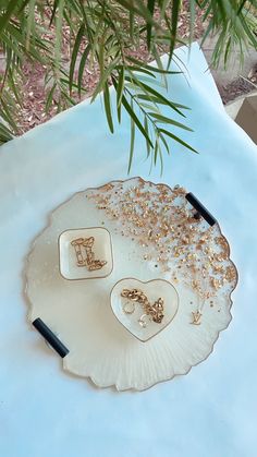 a white plate topped with gold jewelry on top of a table