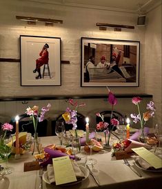 a dining room table is set with flowers and candles