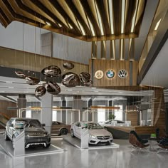 a car showroom with several cars parked in the lot and hanging from the ceiling