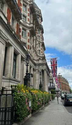 the british flag is flying in front of an old building with many windows and balconies