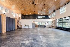 an empty room with wooden ceiling and blue curtains