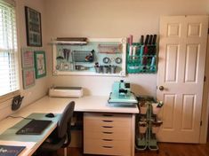 a home office with lots of crafting supplies on the desk and shelves above it