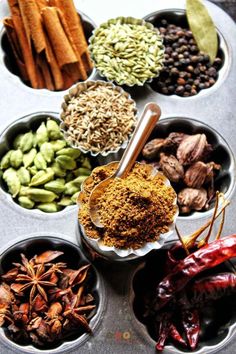 bowls filled with spices and herbs on top of a table