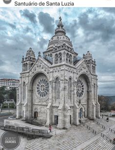 an old church with steps leading up to it and people walking around the building on either side