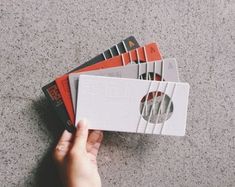 a person holding a stack of cd's on top of each other in their hand