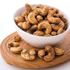 a white bowl filled with donuts on top of a wooden board