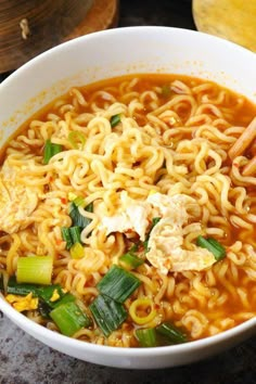 a white bowl filled with noodles and vegetables