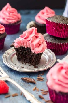 chocolate cupcakes with pink frosting on a plate