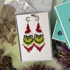 a pair of beaded earrings in a box next to christmas decorations and other items