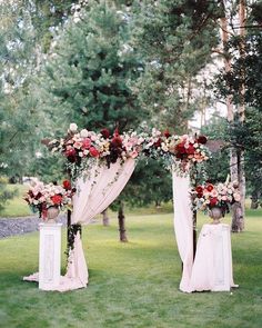 an outdoor ceremony setup with flowers and drapes