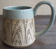 a blue and white coffee mug sitting on top of a wooden table