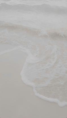 an ocean view with waves coming in to the shore and one person holding a surfboard