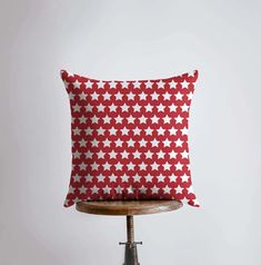 a red and white pillow sitting on top of a wooden table