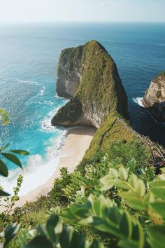 the beach is next to an island with two large rocks on it's side